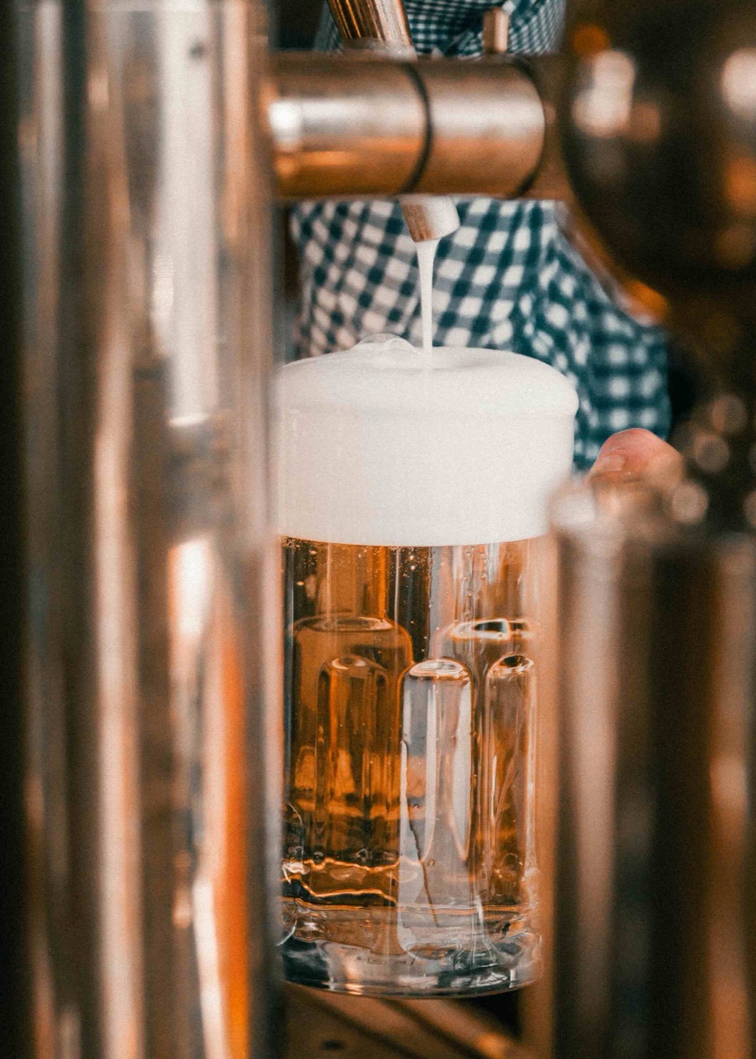 Frisch gezapftes, goldgelbes Tankbier mit cremiger Schaumkrone im Maßkrug