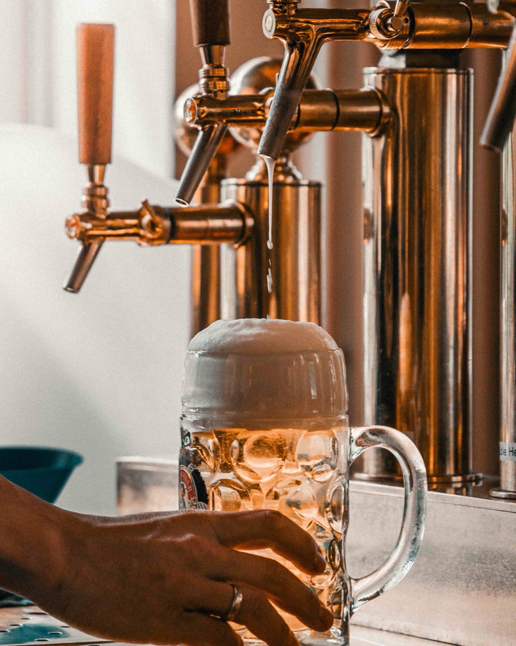 Frisch gezapftes Tankbier läuft aus dem Zapfhahn in einen Maßkrug